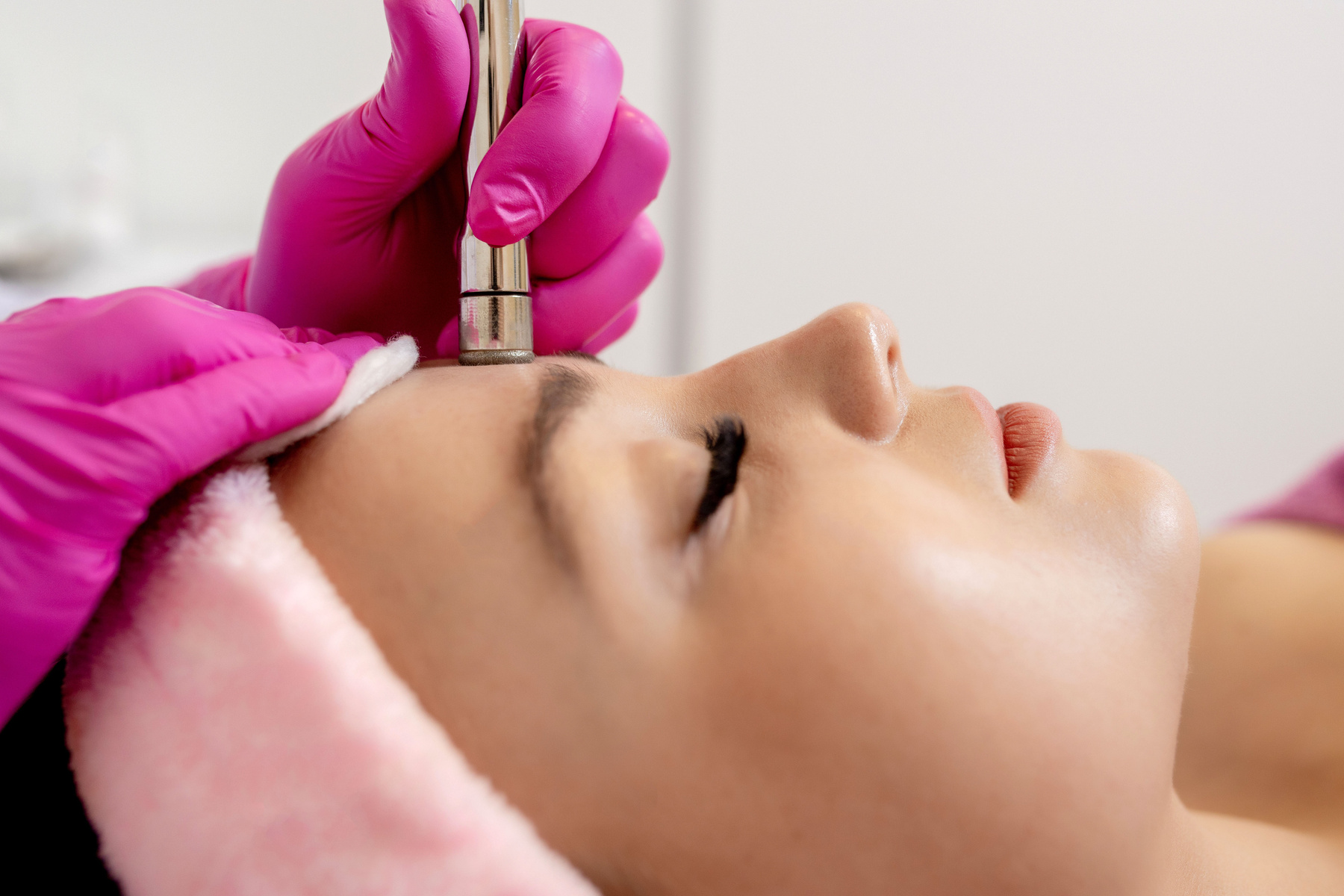 The cosmetologist makes the procedure Microdermabrasion of t